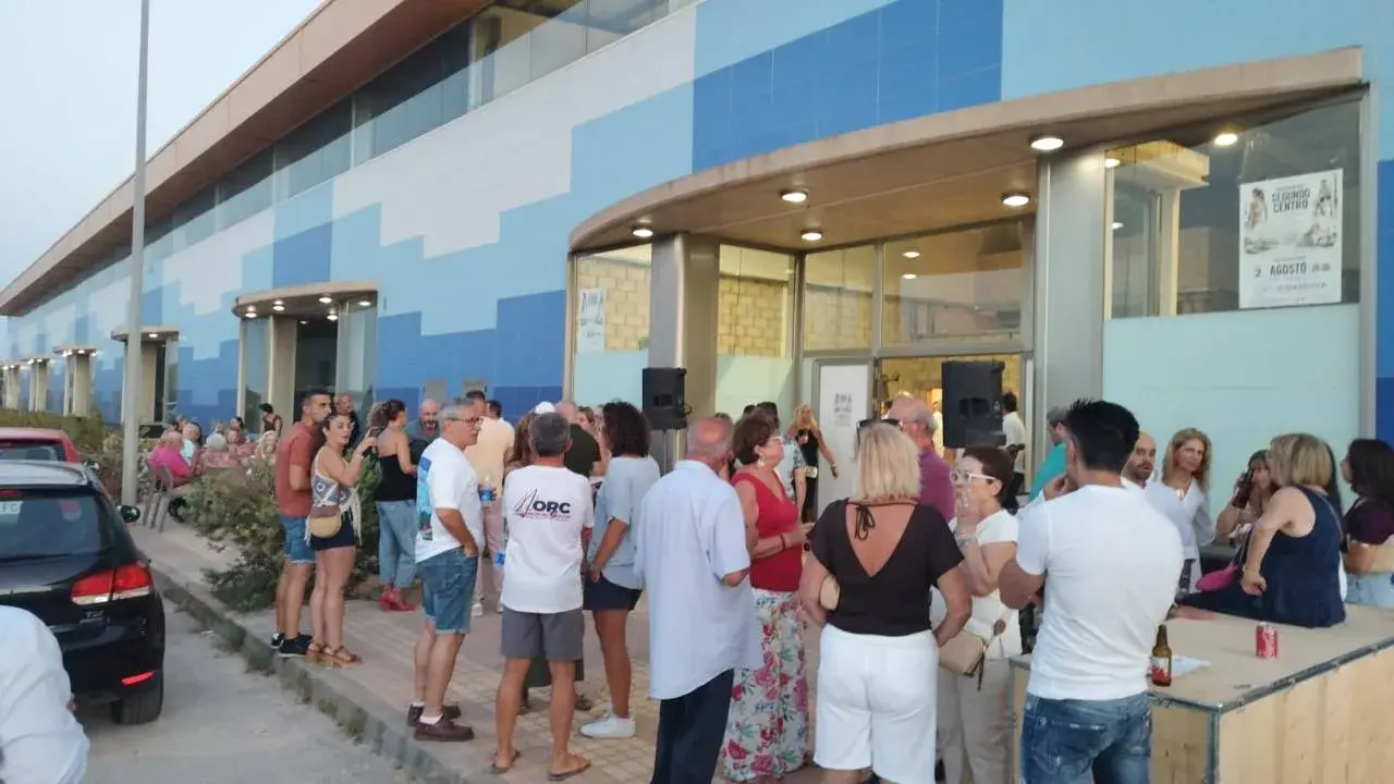 Asistentes ante la entrada del nuevo centro Vida Nova Los Belones durante la inauguración
